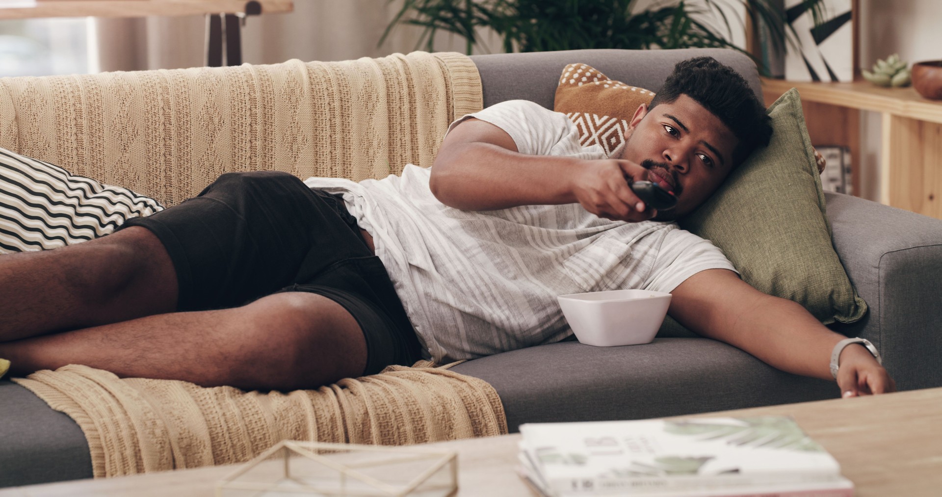 Shot of a young man lying on his couch at home